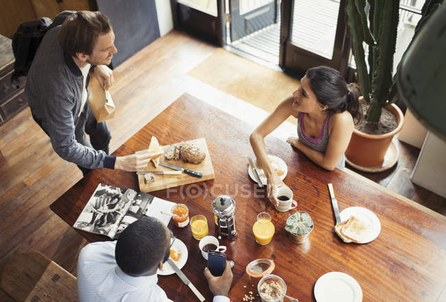 Compañeros de cuarto amigos y desayunando y tomando café en la mesa - foto de stock