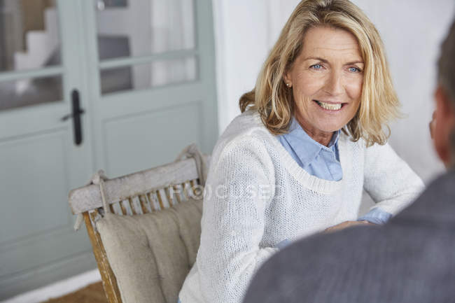 Lächelnde Seniorin im Gespräch mit Ehemann auf der Terrasse — Stockfoto