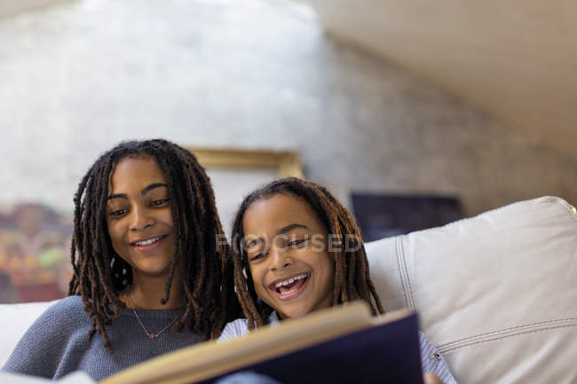 Sorrindo irmãs leitura livro — Fotografia de Stock