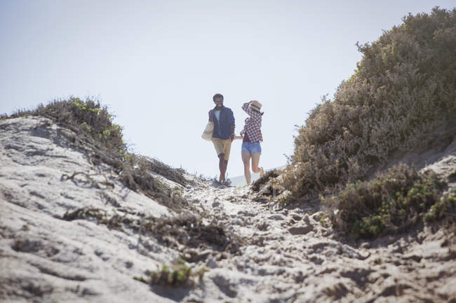 Пара прогулок по солнечному летнему пляжу — стоковое фото