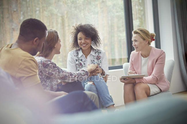 Smiling woman comforting woman in group therapy session — Stock Photo