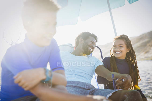 Vater und Kinder entspannen sich am sonnigen Sommerstrand — Stockfoto
