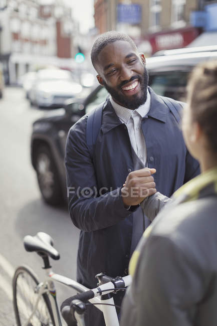 Lächelnder Geschäftsmann mit Fahrrad schüttelt Frau auf Stadtstraße die Hand — Stockfoto