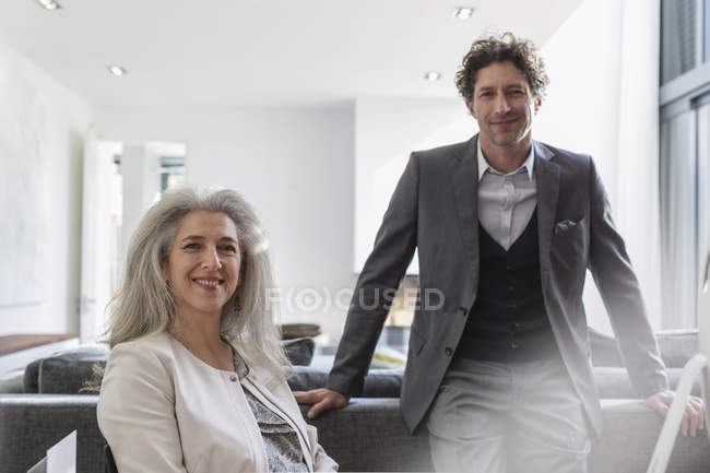 Portrait confident businessman and businesswoman in living room — Stock Photo