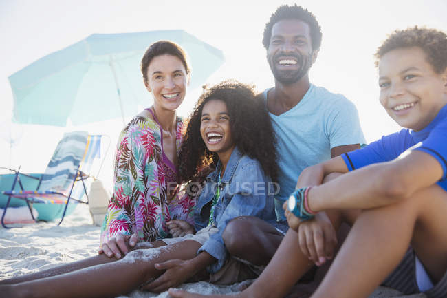 Retrato sonriente, feliz familia multiétnica en la playa de verano - foto de stock