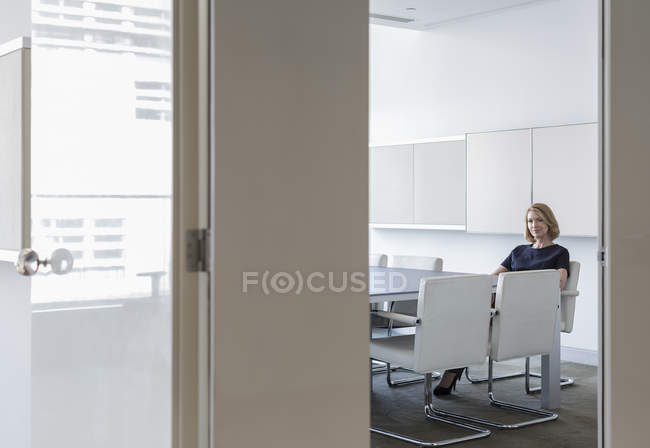 Retrato mujer de negocios esperando en la sala de conferencias en la oficina moderna - foto de stock