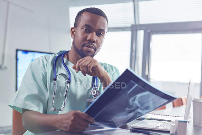 Retrato confiante cirurgião masculino com raio-x no hospital — Fotografia de Stock