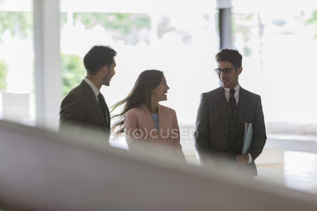 Gente de negocios hablando y caminando en la oficina - foto de stock