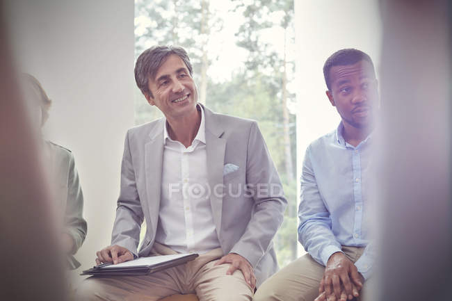 Smiling man listening in group therapy session — Stock Photo