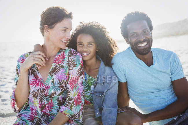 Retrato sonriente, familia multiétnica en la soleada playa de verano - foto de stock