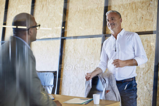 Uomini d'affari che parlano in sala riunioni in un ufficio moderno — Foto stock