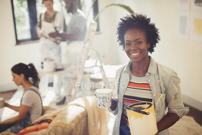 Retrato mulher confiante beber café e pintura sala de estar — Fotografia de Stock