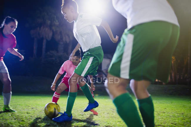Jovens jogadoras de futebol jogam em campo à noite — Fotografia de Stock
