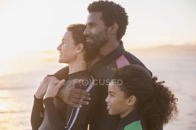Famiglia affettuosa serena che distoglie lo sguardo sulla spiaggia estiva del tramonto — Foto stock