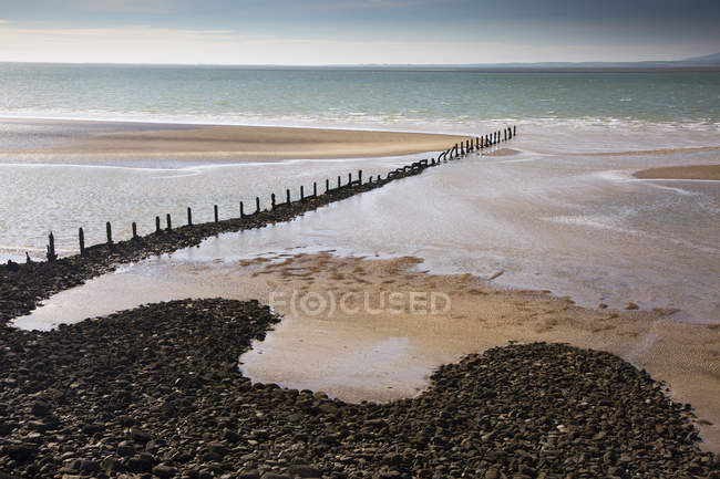 Playa remota del océano con embarcadero escarpado, Heysham, Lancs, Reino Unido - foto de stock