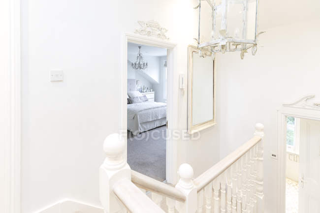 Blanco, hogar escaparate escalera de lujo aterrizaje con vista al dormitorio - foto de stock