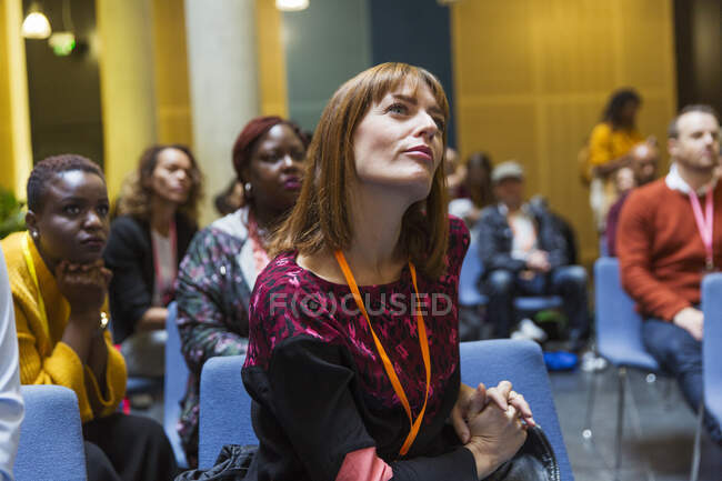 Aufmerksame, fokussierte Geschäftsfrau hört im Konferenzpublikum zu — Stockfoto