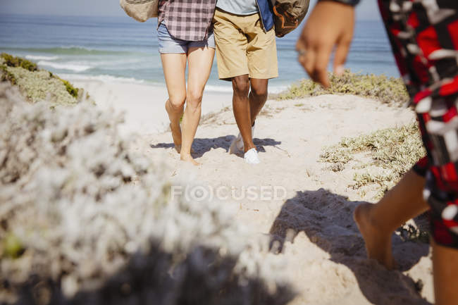 Beine eines multiethnischen Paares auf sonnigem Sommer-Sandstrand-Pfad — Stockfoto