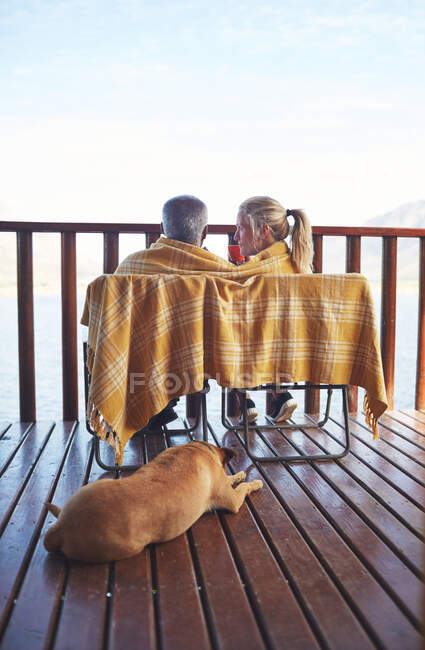 Acogedora pareja y perro en el balcón - foto de stock