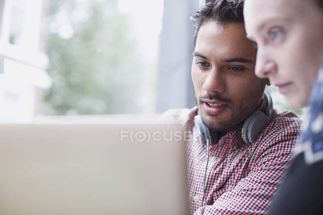Focused young men using laptop in cafe — Stock Photo
