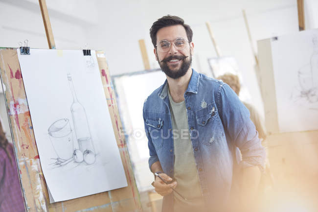 Ritratto sorridente artista maschio con barba schizzo in studio classe d'arte — Foto stock