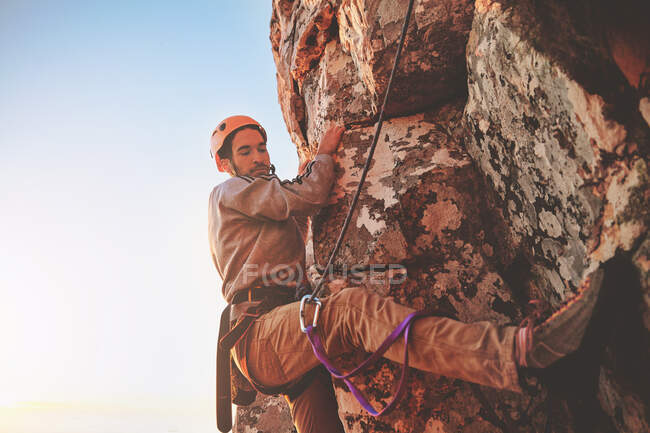 Scalatore di roccia maschio concentrato appeso alla roccia — Foto stock