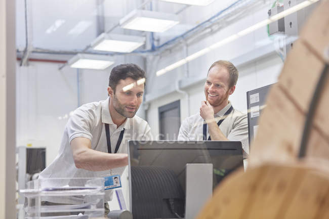 Male supervisors working at computer in factory office — Stock Photo