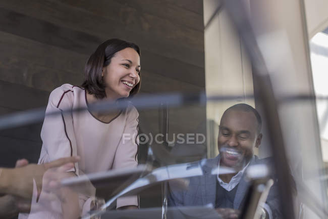 Улыбающийся бизнесмен и деловая женщина разговаривают на встрече — стоковое фото