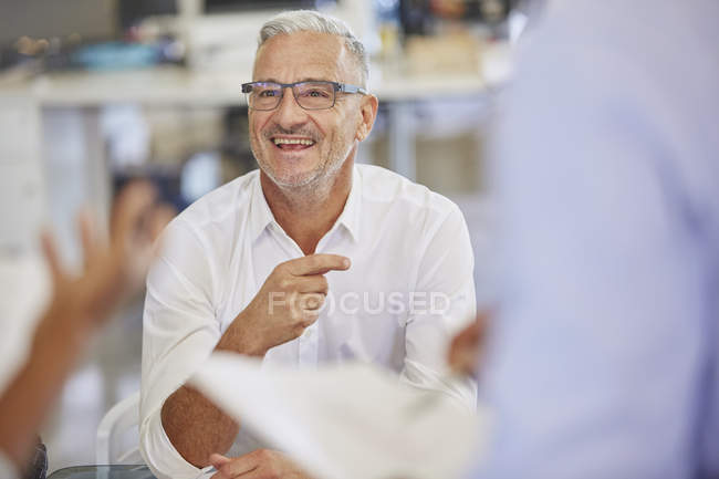 Empresário sorridente em reunião no escritório moderno — Fotografia de Stock