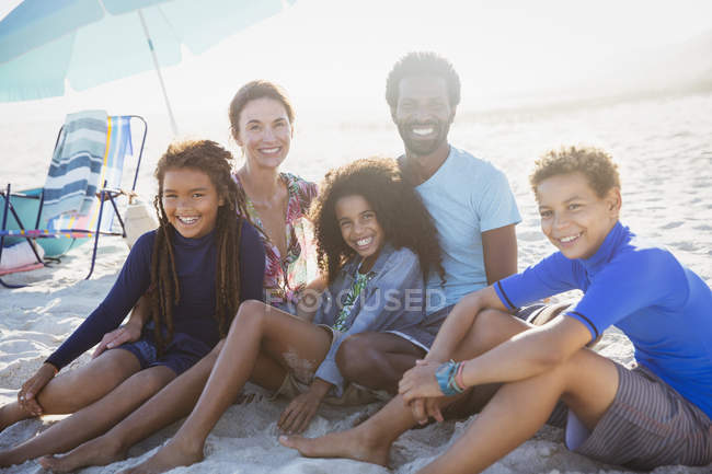 Porträt lächelnde multiethnische Familie am sonnigen Sommerstrand — Stockfoto