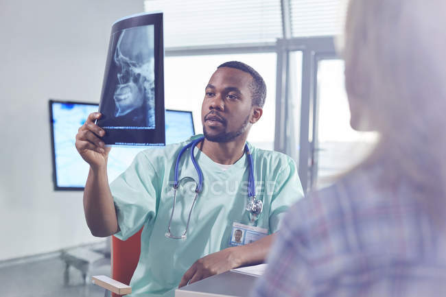 Cirurgião masculino examinando raio-X do crânio no hospital — Fotografia de Stock