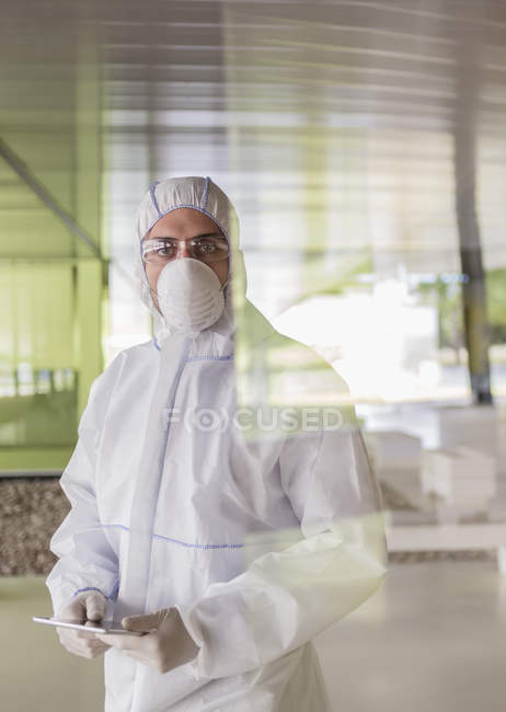 Retrato científico serio en traje limpio usando tableta digital - foto de stock