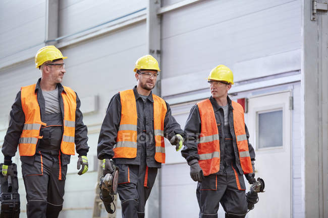 Чоловіки робітники в захисному одязі ходять — стокове фото