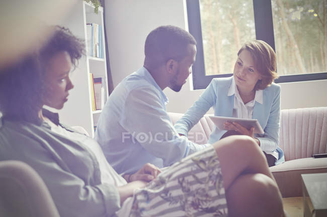 Therapeutin mit digitalem Tablet tröstet Mann in Paartherapie-Sitzung — Stockfoto