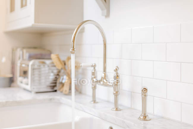 Acqua che scorre dal rubinetto del lavandino della cucina — Foto stock