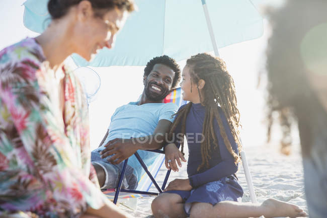 Sorrindo pai e filha na ensolarada praia de verão — Fotografia de Stock
