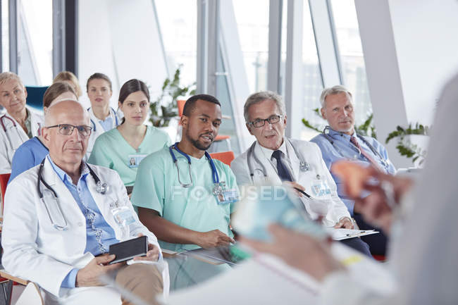Хірурги, лікарі та медсестри слухають аудиторію конференції — стокове фото