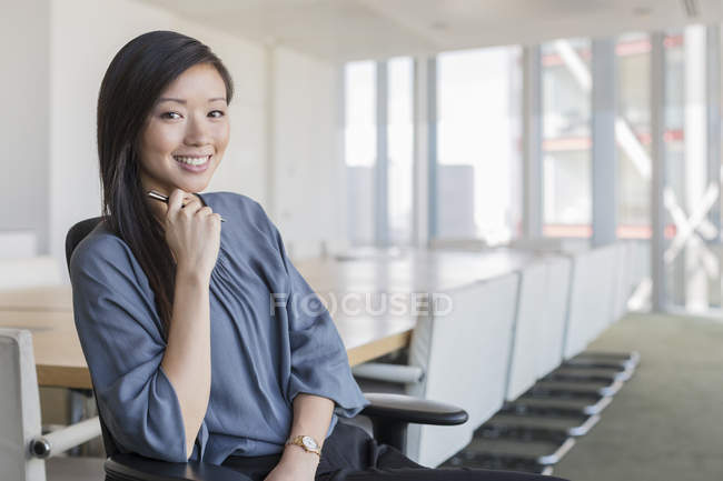 Retrato confiante empresária na sala de conferências — Fotografia de Stock