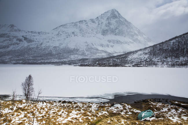Tranquilas y remotas montañas escarpadas cubiertas de nieve y fiordo, Austpollen, Hinnoya, Noruega - foto de stock
