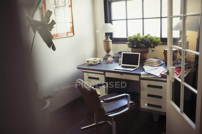 Portatile e scartoffie sulla scrivania in ufficio — Foto stock