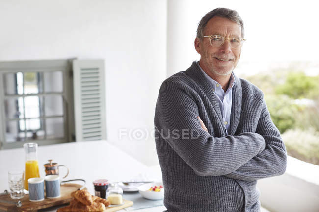 Retrato sorrindo homem sênior no café da manhã na mesa do pátio — Fotografia de Stock