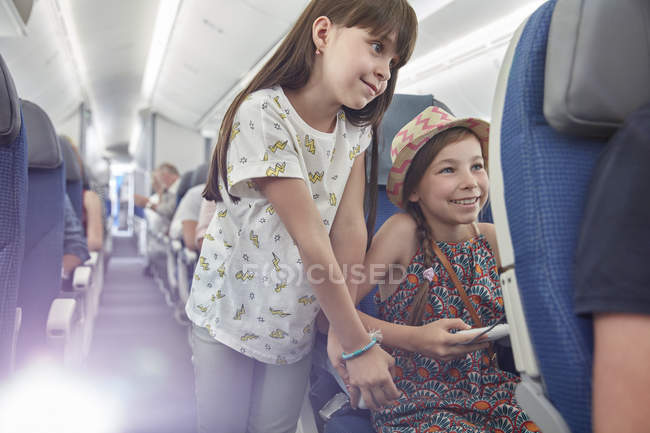 Girl sisters playing video game on airplane — Stock Photo