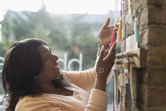 Woman browsing mala beads in shop — Stock Photo