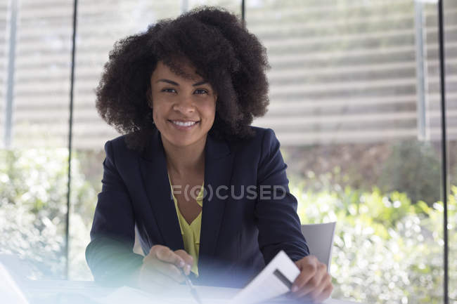 Porträt lächelnde, selbstbewusste Geschäftsfrau bei der Überprüfung von Papieren — Stockfoto
