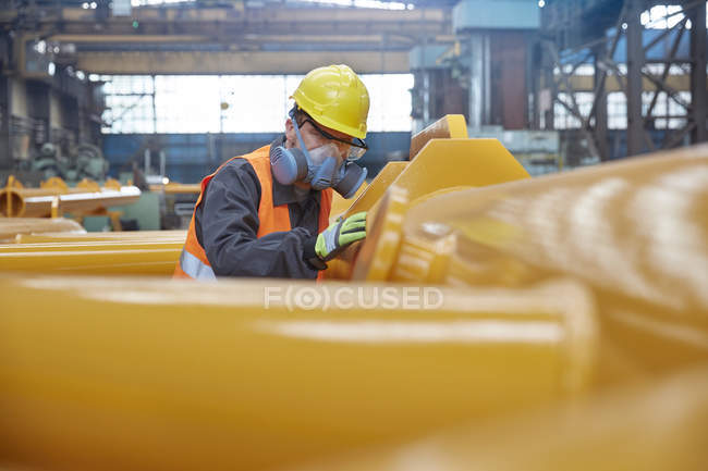 Steel worker wearing protective face mask, examining equipment in steel factory — Stock Photo