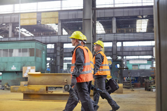 Trabalhadores do sexo masculino andando em fábrica de aço — Fotografia de Stock