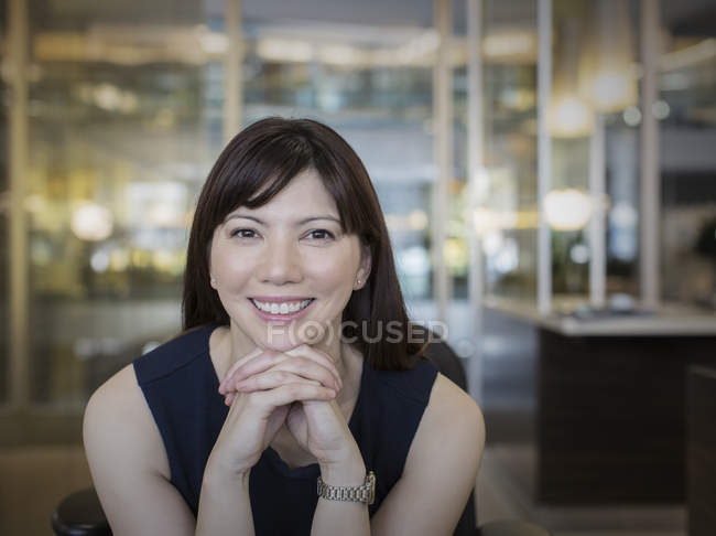 Портрет улыбающейся деловой женщины с сжатыми руками — стоковое фото