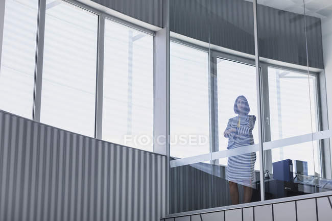 Портрет впевнена генеральна бізнес-леді стоїть у сучасному офісному вікні — стокове фото