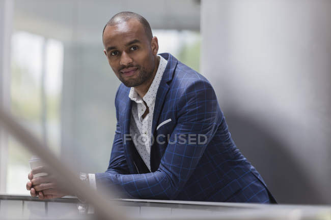 Portrait confident businessman leaning on railing — Stock Photo
