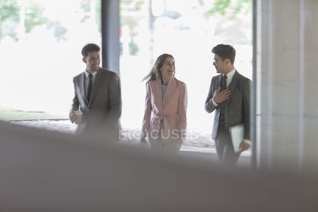 Gente de negocios caminando y hablando en la oficina - foto de stock